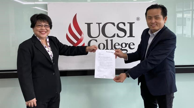 Associate Professor Dr Mabel Tan, President and CEO of UCSI College (left) presenting the letter of appointment to (Dr) Alan Poon.